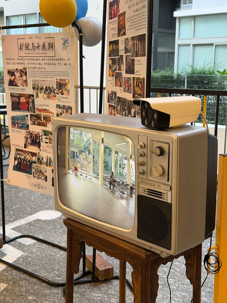 Vintage TV displaying a live camera feed at a church anniversary celebration